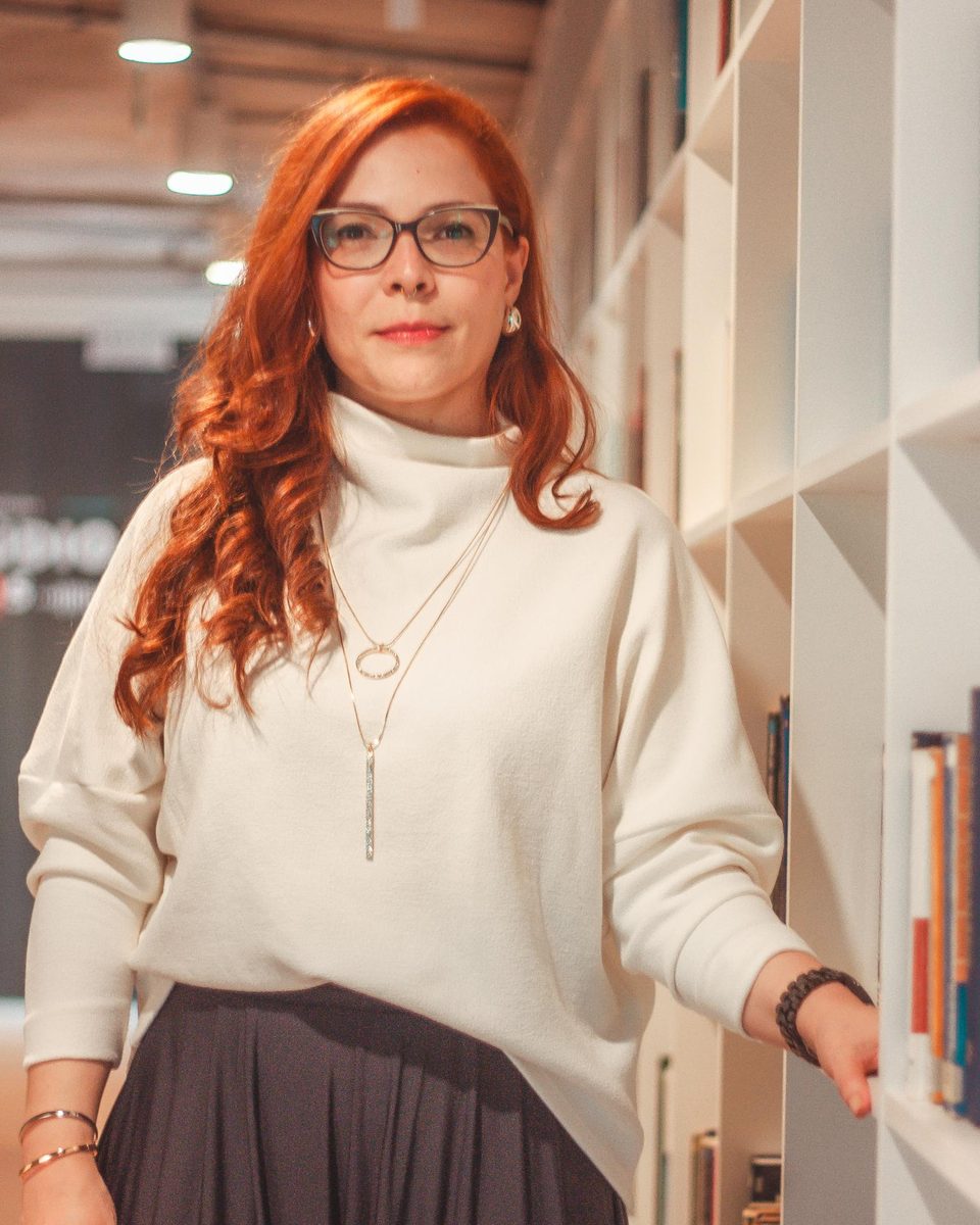 Dra. Kelly Marques Tavares, advogada, junto a uma estante de livros